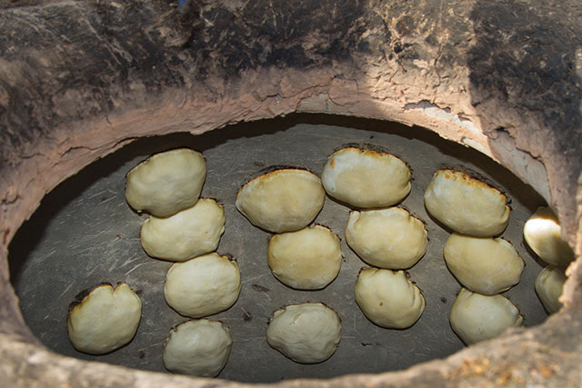 A tandoor oven preparing bread